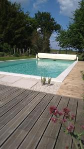una piscina blu con un ponte di legno e fiori di Longère du sud Touraine au Coeur du Val de Loire a Saint-Jean-Saint-Germain