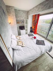 um quarto com uma cama e uma grande janela em Africa panoramique By Carl-Emilie em Épinal