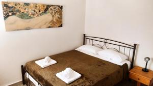 een slaapkamer met een bed met twee witte handdoeken erop bij Appartement Heraklion - Vue mer et montagne in Heraklion