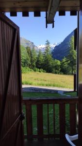 a door to a porch with a view of a field at Appartamento Gressoney-Saint-Jean (Obre Biel) - I Larici in Gressoney-Saint-Jean
