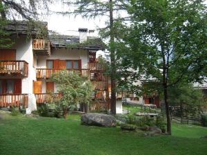 a building with balconies and a yard with a tree at Appartamento Gressoney-Saint-Jean (Obre Biel) - I Larici in Gressoney-Saint-Jean