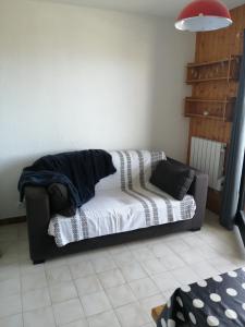 - un canapé avec une couverture dans l'établissement Le balcon des Memises, à Thollon-les-Mémises