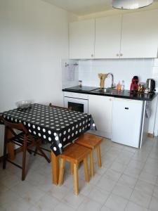 a kitchen with a table and chairs and a sink at Le balcon des Memises in Thollon +21 photos