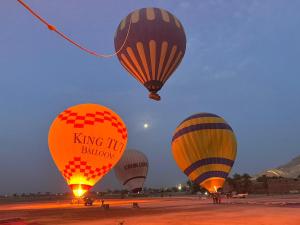 un grupo de globos de aire caliente volando en el cielo en Peace & Freedom Guesthouse & Restaurant en Luxor