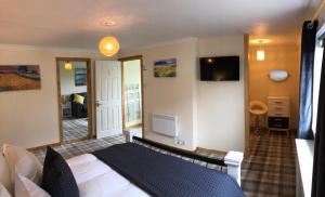 a bedroom with a bed and a tv on the wall at Old School - Exclusive 5 Room private suite in Orkney