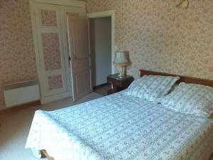 a bedroom with a bed with a blue comforter at maison de campagne en pierre in Dégagnac
