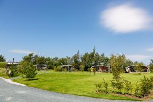 a grassy field with a park with trees and buildings at Fell View Park Escape Pods with hot tubs in Kirkby Lonsdale