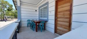 een kleine veranda met een tafel en stoelen op een huis bij JCALM Beach resort in Bulala