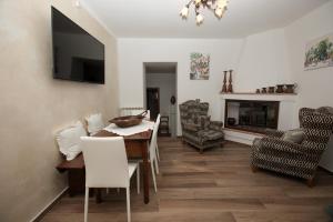 a living room with a table and chairs and a television at Affittacamere Nonna Rosa in Vallo di Nera