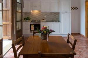 a kitchen with a wooden table with a vase of flowers on it at Agriturismo De Santis in Castiglioncello