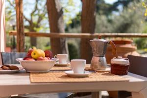 a table with a bowl of fruit and a tea kettle at Agriturismo De Santis in Castiglioncello