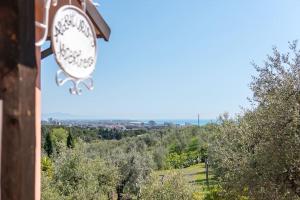 a clock on the side of a building with trees at Agriturismo De Santis in Castiglioncello