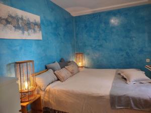 1 dormitorio con 1 cama grande y paredes azules en Stone Villa Hvar Ana and Nikola Beachfront, en Jelsa