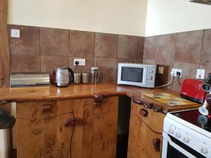 cocina con encimera de madera y microondas en The Annex, Kilbride Farmhouse, en Dunoon
