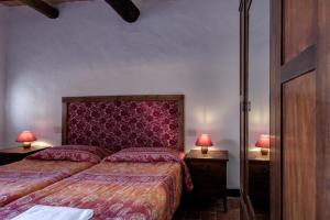 a bedroom with a bed and two night stands with lamps at Agriturismo Tenuta Di Mensanello in Colle di Val d'Elsa