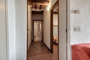 un pasillo que conduce a un dormitorio con espejo en Agriturismo Tenuta Di Mensanello, en Colle Val D'Elsa