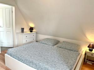 um quarto branco com uma cama e uma cómoda em Tonne 1 em Eckernförde