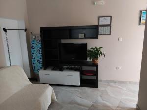 a living room with a flat screen tv on a stand at Modrika Apartments in Zablaće