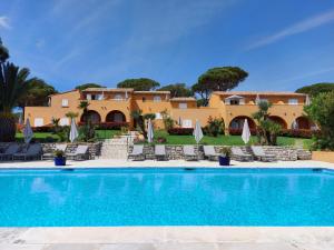 a villa with a swimming pool and a resort at Hôtel les Bouis - Vue mer in Saint-Tropez