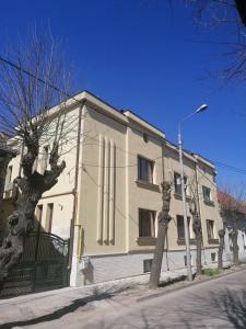 un bâtiment blanc avec un arbre devant lui dans l'établissement NOVA Lake apartamente, à Satu Mare