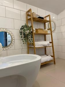 La salle de bains est pourvue de toilettes blanches et d'une étagère avec des serviettes. dans l'établissement NOVA Lake apartamente, à Satu Mare