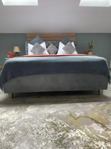 - un lit avec des oreillers bleus et blancs dans une chambre dans l'établissement NOVA Lake apartamente, à Satu Mare