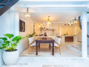 cocina y comedor con mesa de madera y sillas en The Oberoi Luxury Villas Seminyak, en Seminyak