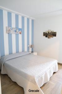 a bedroom with a bed with blue and white stripes at Casa Piano Ponente in Isola delle Femmine