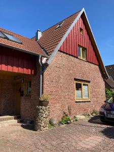 uma casa de tijolos vermelhos com um telhado vermelho em Tonne 1 em Eckernförde