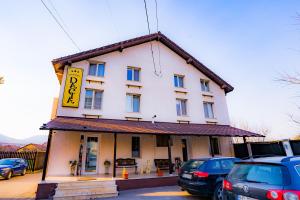 un gran edificio blanco con un cartel. en Pensiunea Dacia Deva en Deva