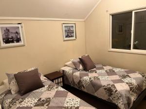 a bedroom with two beds and a window at Apart Hotel Chillan - Home Cozy - Empresas - Factura - Aire acondicionado in Chillán