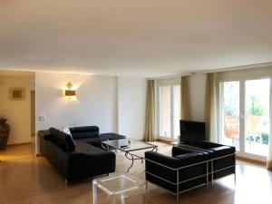 uma sala de estar com dois sofás pretos e uma televisão em Centrally located, Spacious Modern Apartment em Zürich