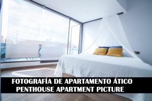 una camera con un letto bianco e una grande finestra di Apartments Madrid Plaza Mayor-Tintoreros a Madrid