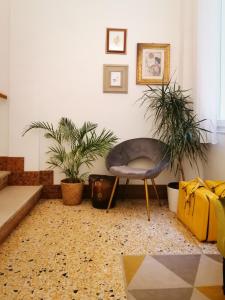 a living room with a chair and two plants at Hotel Lauri in Macerata