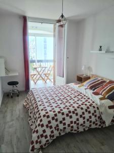 a bedroom with a bed and a balcony with a table at Escapade Montesquieu in Perpignan