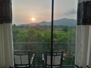 a balcony with chairs and a view of the sunset at Ridge Boundary View in Dambulla
