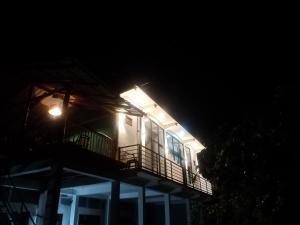 a house with a light on the balcony at night at Ridge Boundary View in Dambulla