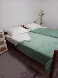 two beds sitting next to each other in a room at Apartments Sunag in Šibenik