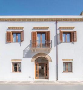 a white building with a balcony and an entry way at Antiche Dimore in Mazara del Vallo