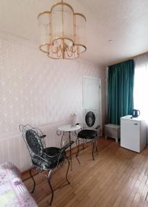 a bedroom with a table and chairs and a chandelier at Guest House Krista in Jūrmala
