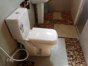 a bathroom with a toilet with rocks on the floor at Ridge Boundary View in Dambulla