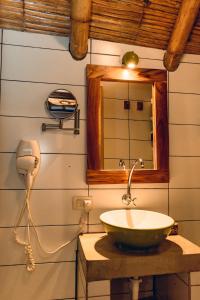 W łazience znajduje się umywalka i lustro. w obiekcie Tiki Limbo w mieście Montañita