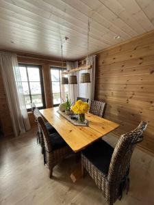 uma sala de jantar com uma mesa de madeira e cadeiras em Cabin in beautiful surroundings at Harpefossen em Nordfjordeid