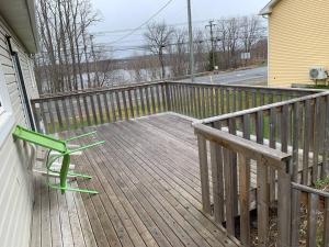 2 sillas verdes en una terraza de madera en Classy and comfy 3-bedroom house. en Fredericton