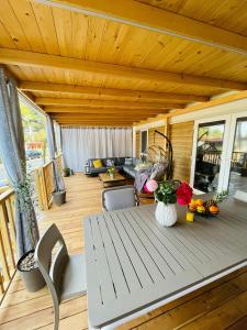 una terrazza in legno con un tavolo e fiori di Iris Holiday Homes - Camping park Soline a Biograd na Moru