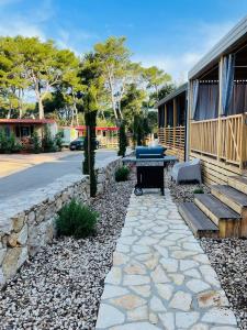 un patio con griglia e panca accanto a un edificio di Iris Holiday Homes - Camping park Soline a Biograd na Moru