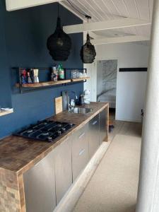 a kitchen with a sink and a stove top oven at Strandvakantiehuisje! in Workum +16 photos