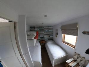 a small room with two beds and a window at Strandvakantiehuisje! in Workum