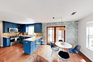 eine Küche mit blauen Schränken sowie einem Tisch und Stühlen in der Unterkunft Victorian Dream in Arroyo Grande