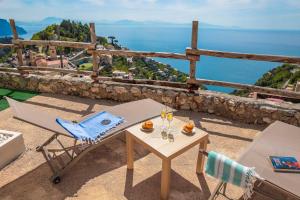 a table and chair with wine glasses on a balcony at Villa Salice in Amalfi